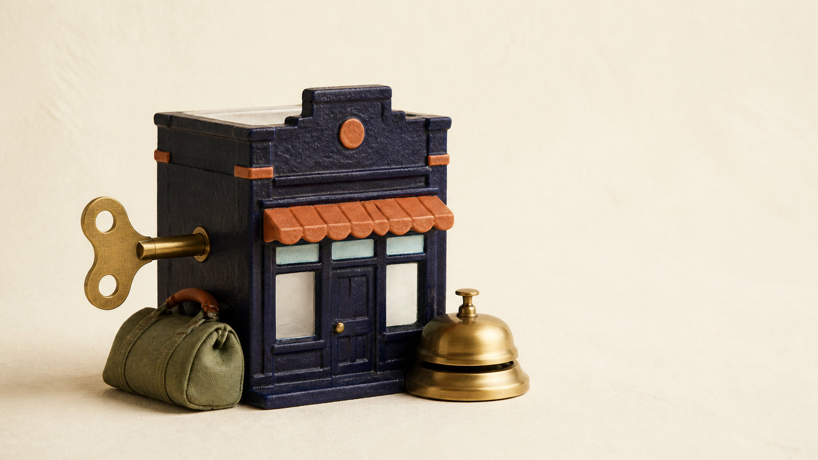 A small ceramic shop model with a brass wind-up key in its side, a folded duffel bag leaning against it
